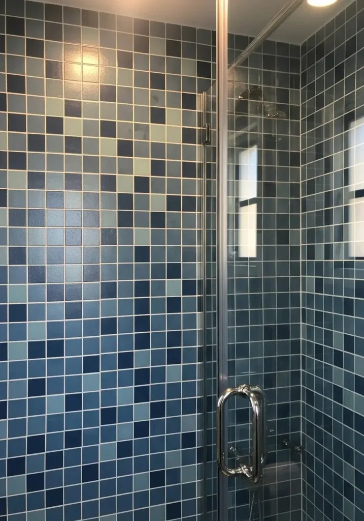 Blue mosaic tiles creating textured shower wall.