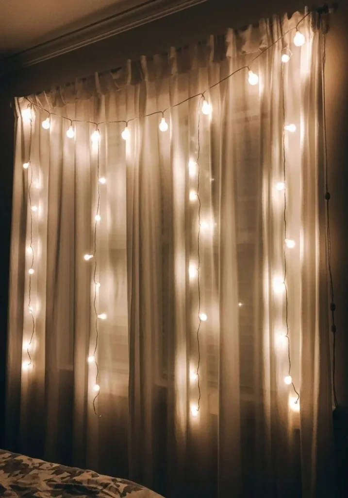 Soft glowing string lights behind sheer curtains creating dreamy bedroom lighting